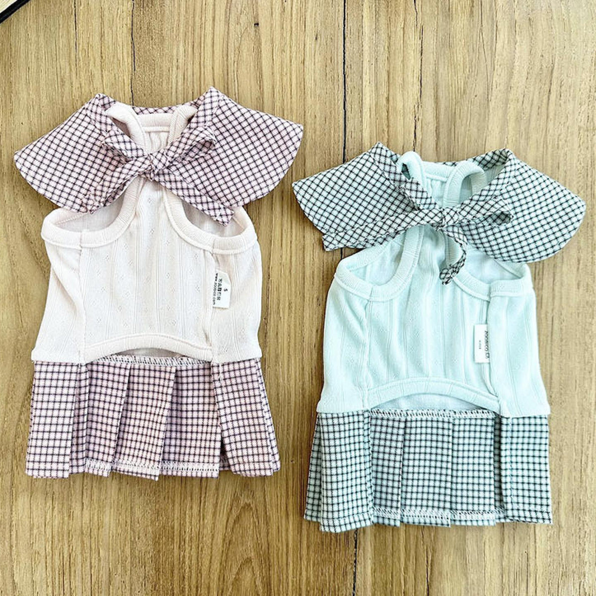 Two NKpup gingham collar pleated pet dresses in pink and mint green.