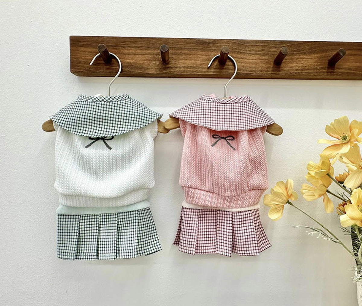 Two NKpup gingham collar pleated dresses for pets, one in white and one in pink.