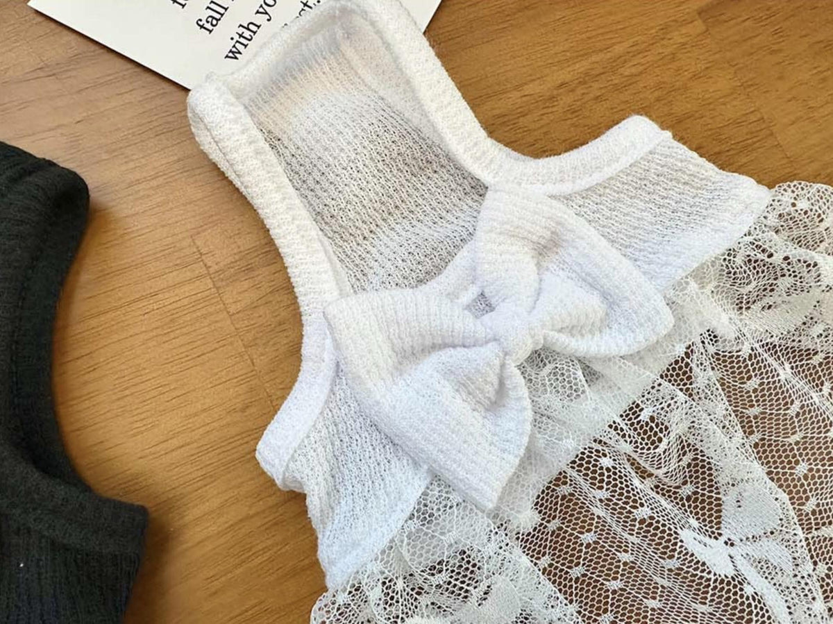 Close-up of the white NKpup Midnight Tulle Bow Dress featuring a lace bodice and decorative bow.