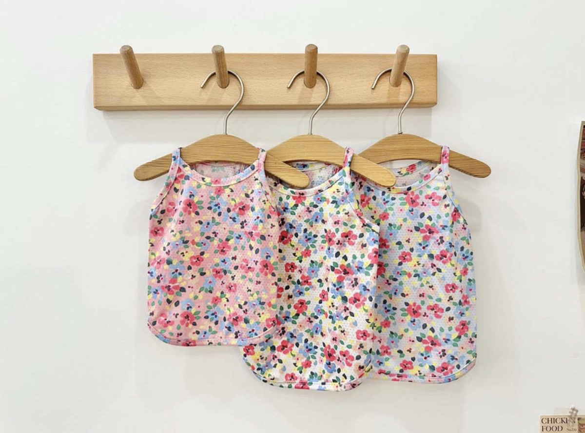 Three NKpup floral cooling mesh dog shirts in colorful flower patterns hanging on wooden hangers.