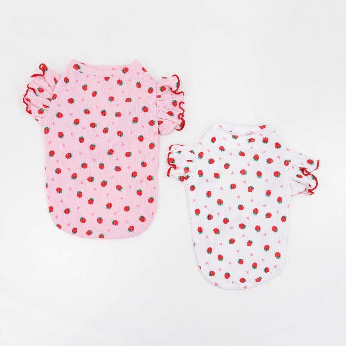 Two NKpup strawberry print dog shirts with ruffled sleeves, one in pink and one in white.
