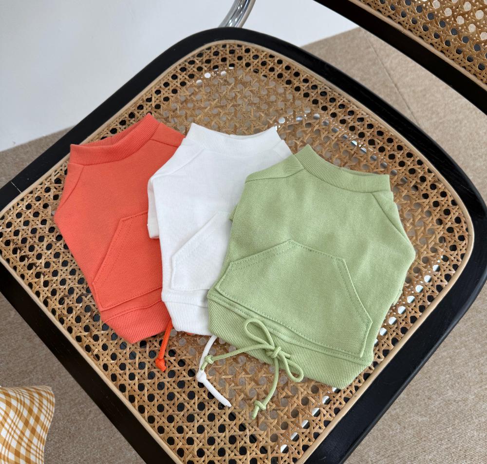 Three NKpup minimal drawstring sweatshirts for dogs in coral, white, and sage green.