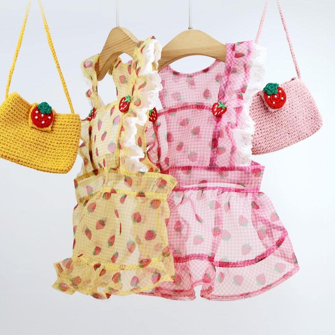 Strawberry Picnic dog dresses in yellow and pink with ruffle details and strawberry patterns.