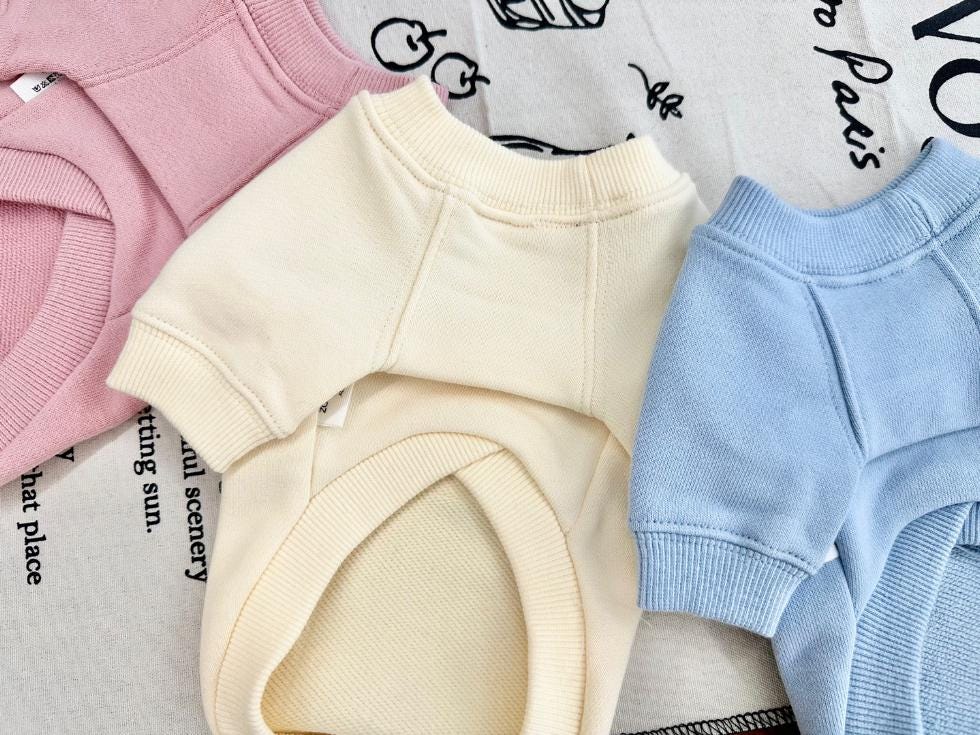 NKpup Good Luck sweatshirt dog shirts in pink, cream, and light blue.