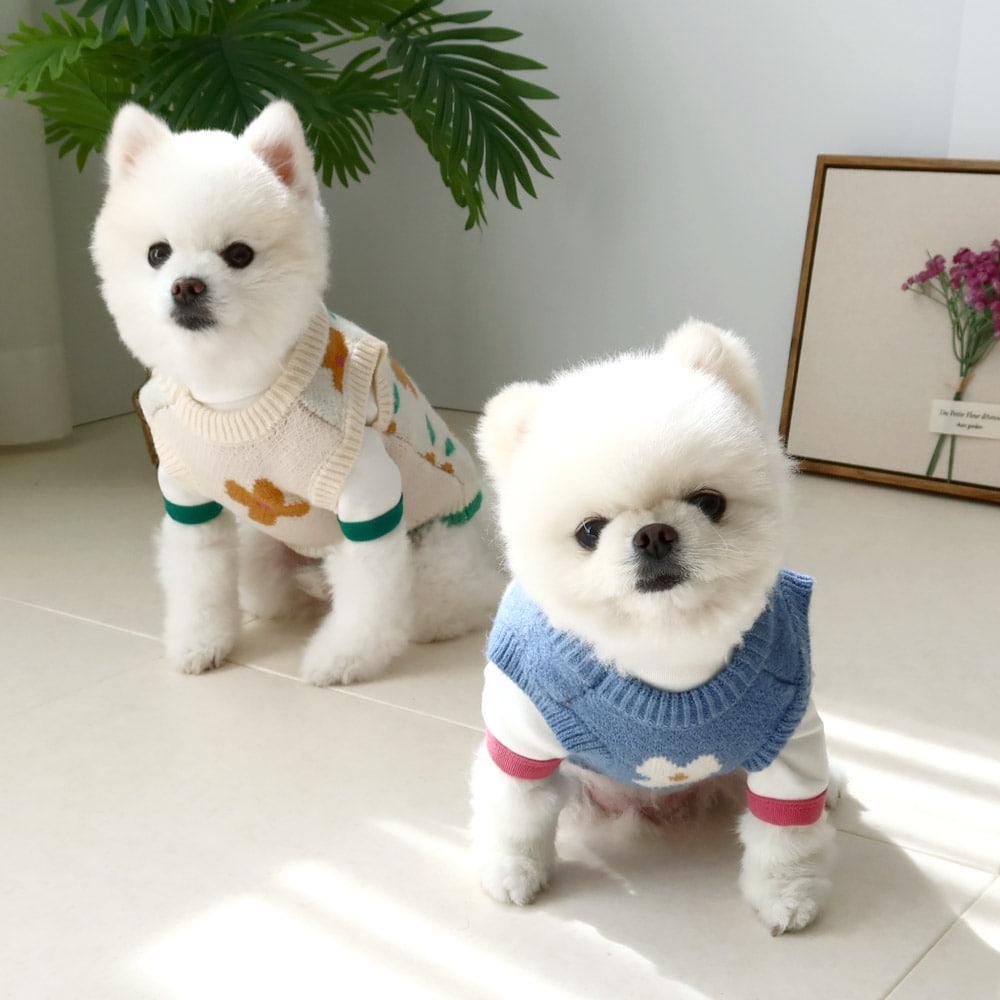 Two white dogs wearing NKpup soft turtleneck dog sweaters with floral patterns.