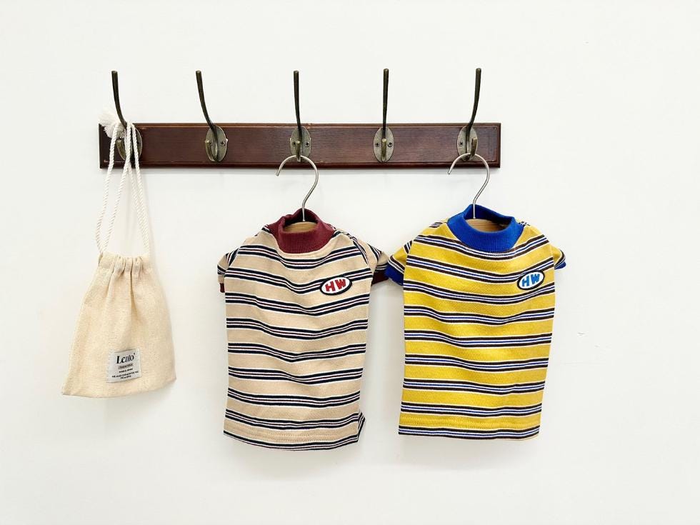 Two HW stripe dog shirts, one beige with black stripes and one yellow with navy stripes.