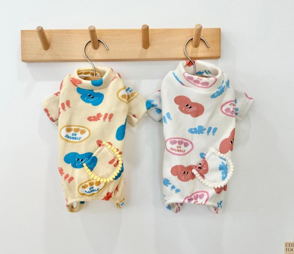 Two Snuggly Print Overalls for pets in cream and white with colorful cartoon patterns.