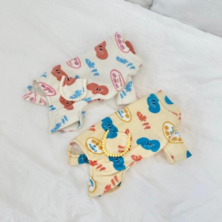 NKpup Snuggly Print Overall dog rompers in cream with colorful smiley face patterns and small pockets.