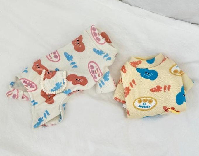 NKpup Snuggly Print Overall pet romper with colorful character patterns in white and cream.