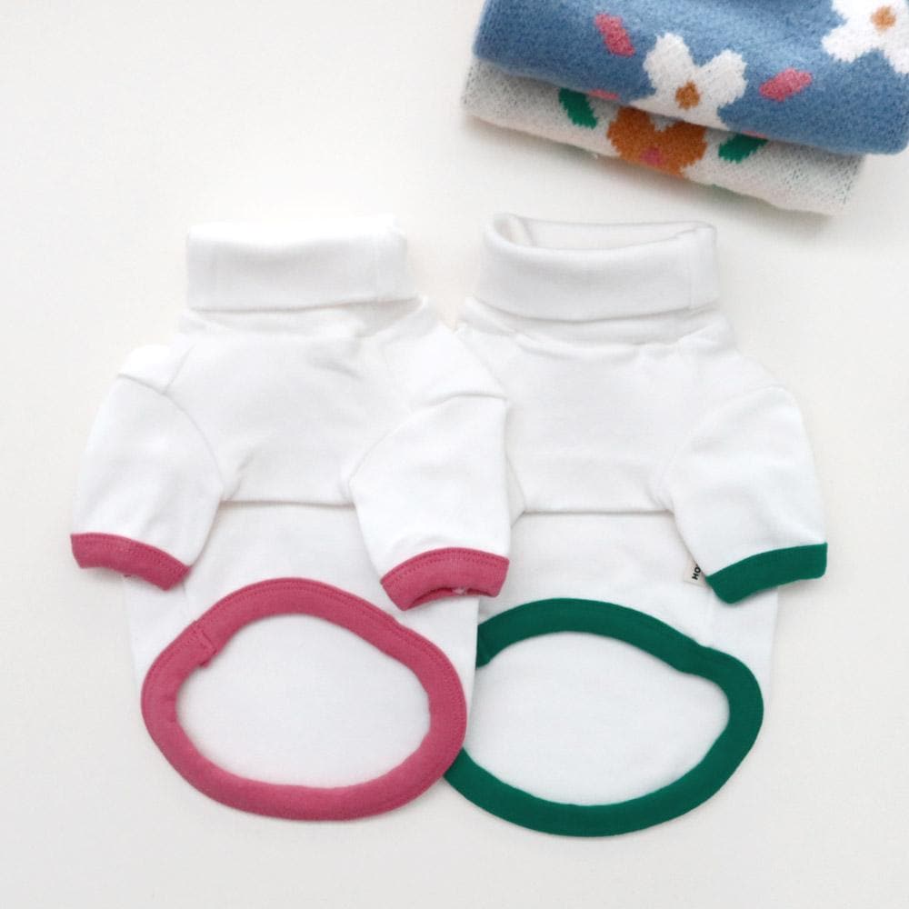 Two white NKpup Daisy Knit Dog Vests with pink and green contrast trim.