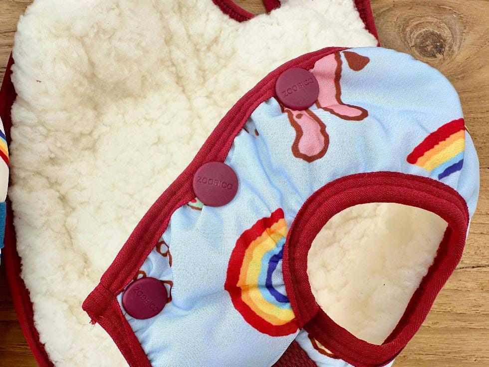 NKpup OMG D-Ring Padded Dog Vest in light blue with rainbow patterns and cream sherpa lining.