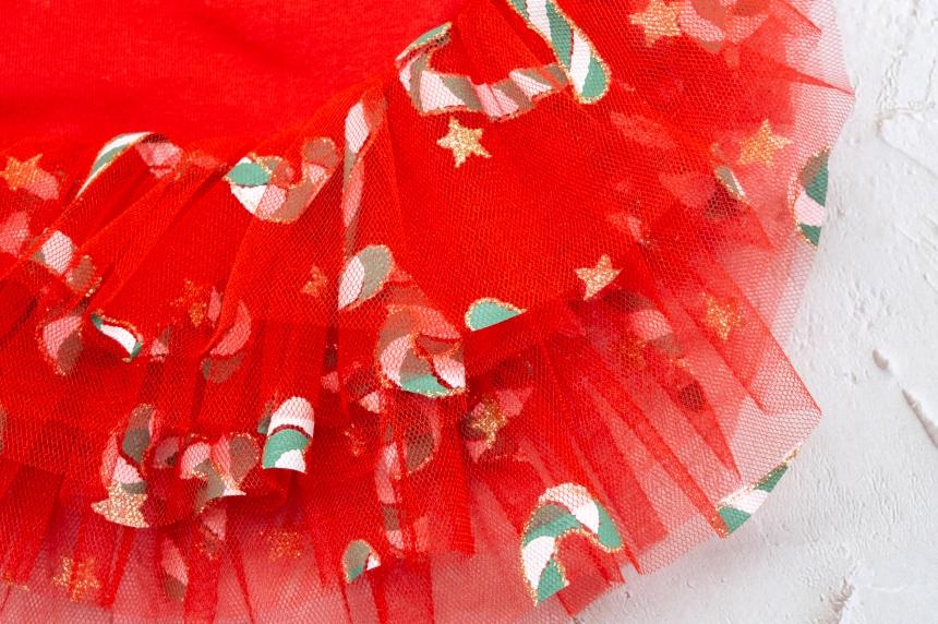 Red Christmas dog dress featuring a candy cane and gold star pattern with ruffled tulle skirt.