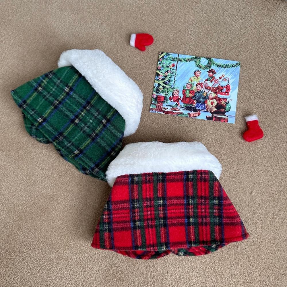 Red and green plaid Christmas reindeer dog capes with white faux fur trim.