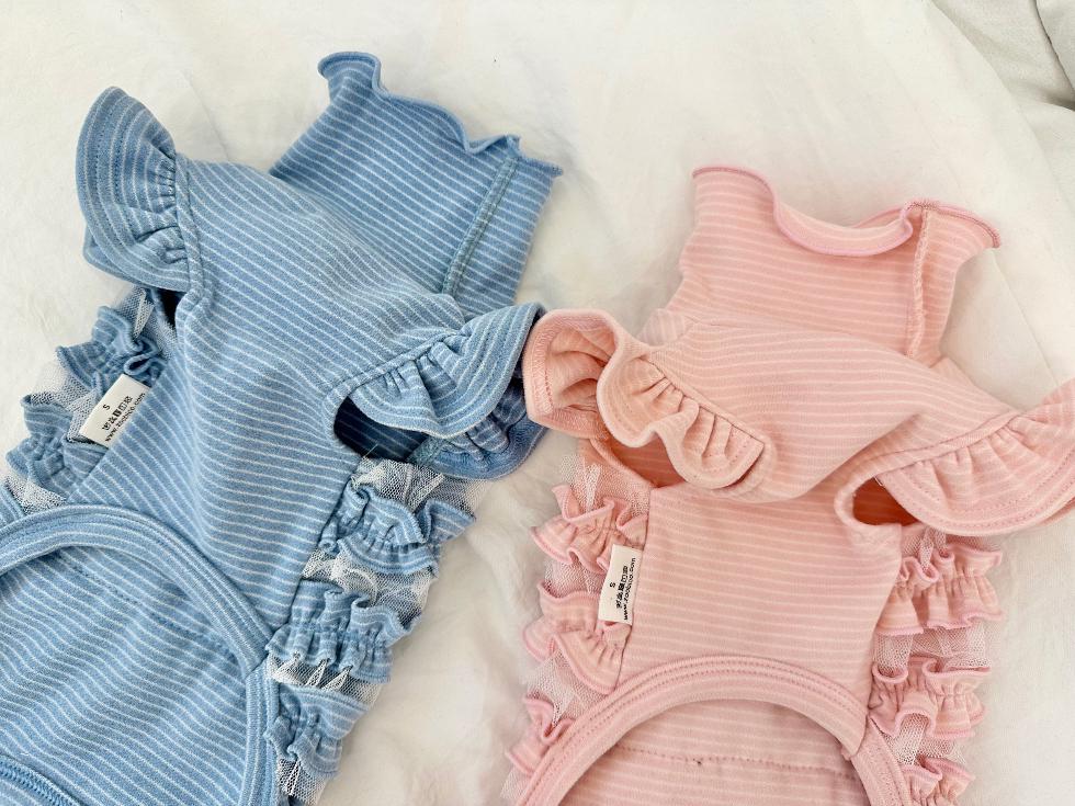 NKpup ruffle ribbed dog overalls in light blue and pink with delicate frill detailing.