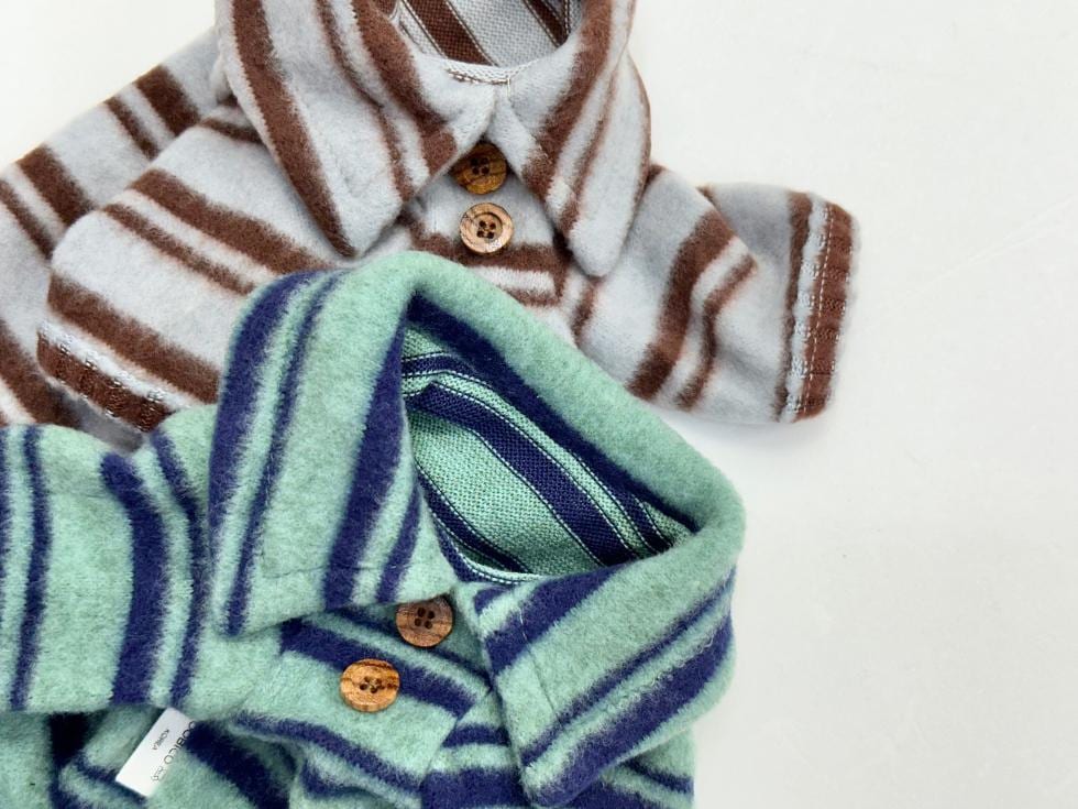 Two striped fleece dog polo shirts in brown and teal colors with wooden buttons.