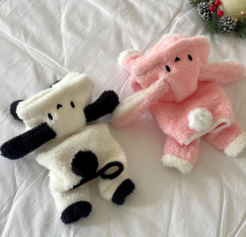 Two plush bunny fleece overalls for pets, one in white with black ears and one in pink.