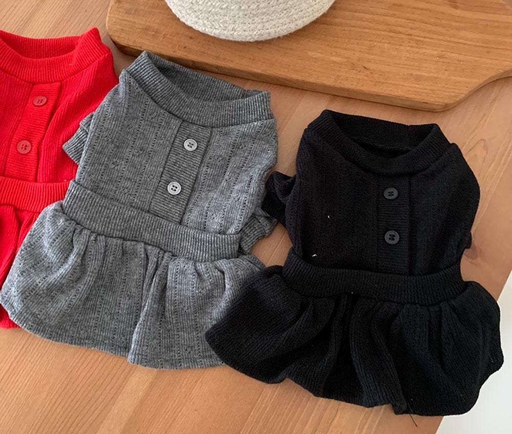 Three chic knit peplum dog dresses in red, grey, and black with button details.