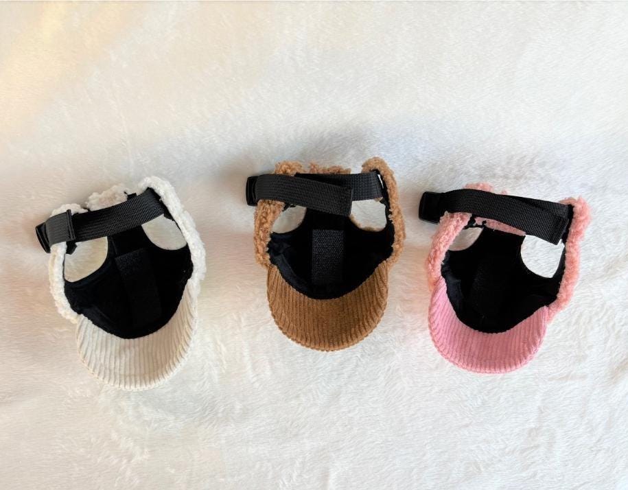 Three NKpup teddy fleece caps for pets in white, brown, and pink colors.