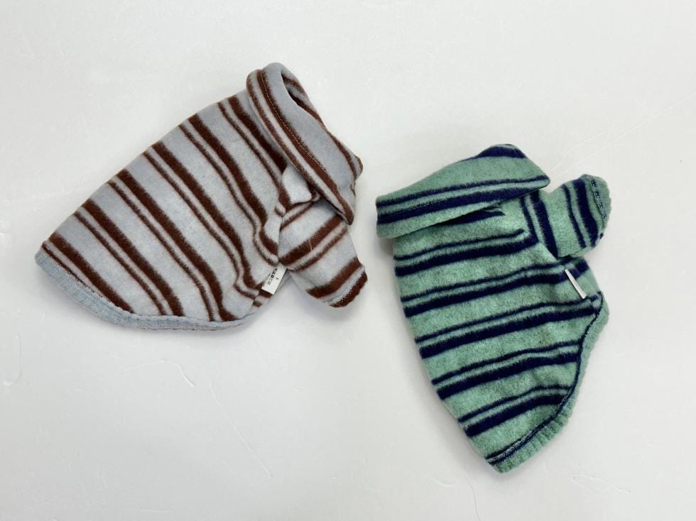 Two striped fleece dog polo shirts, one in grey with brown stripes and one in mint with dark blue stripes.