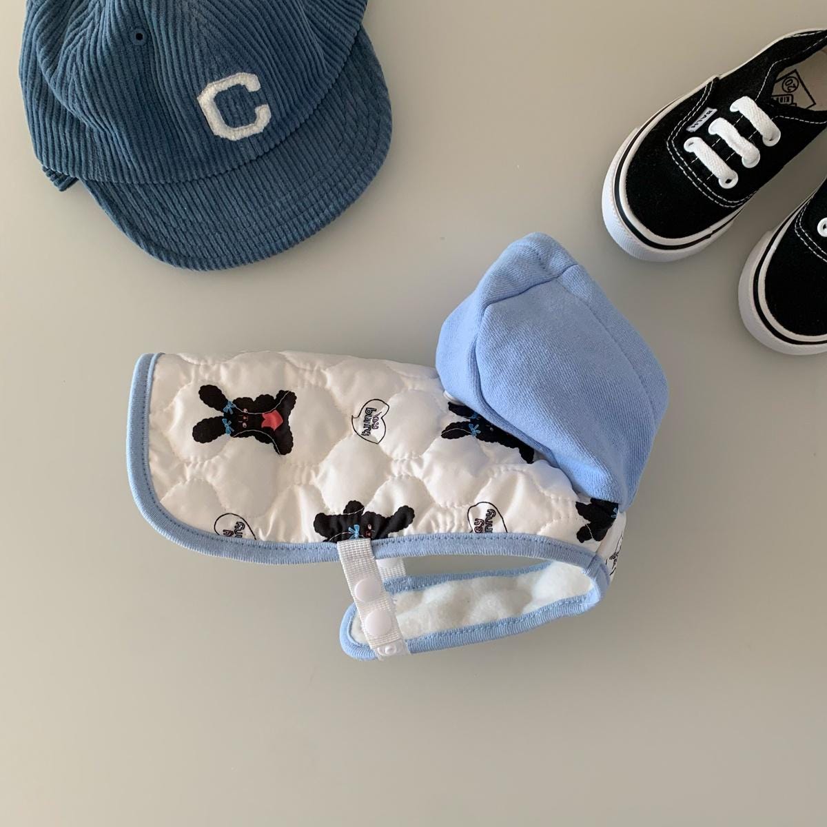 NKpup quilted dog vest in white with light blue trim and black bear pattern