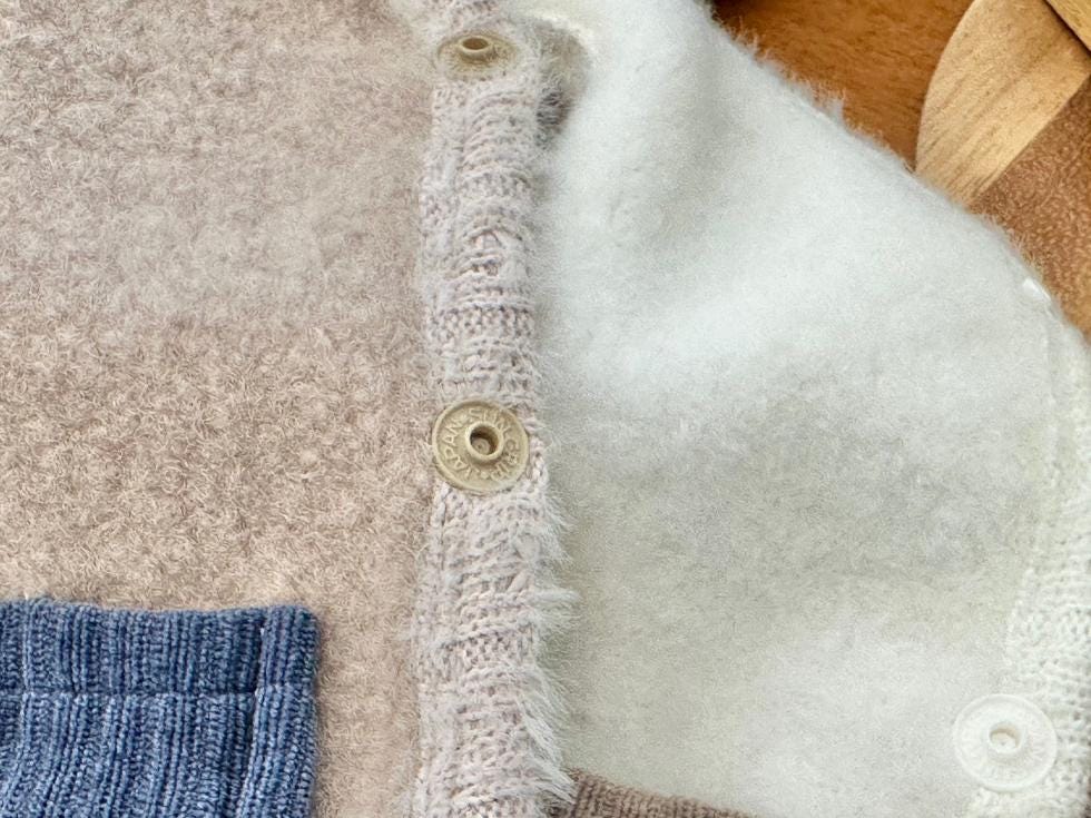 Close-up of a beige NKpup Angora Fleece Dog Vest featuring buttons and a soft white lining.