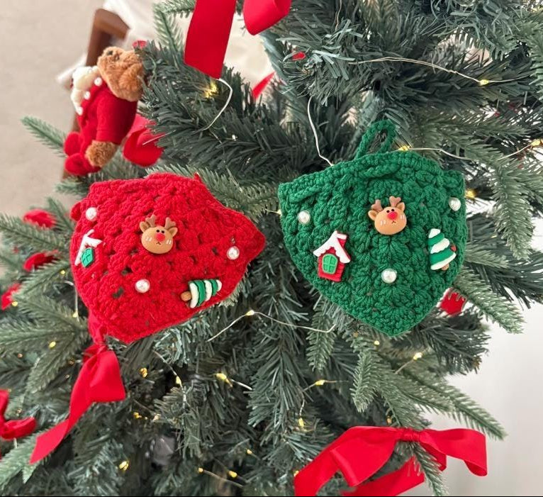 Red and green crochet Christmas dog cape and hat set with reindeer and holiday ornaments.