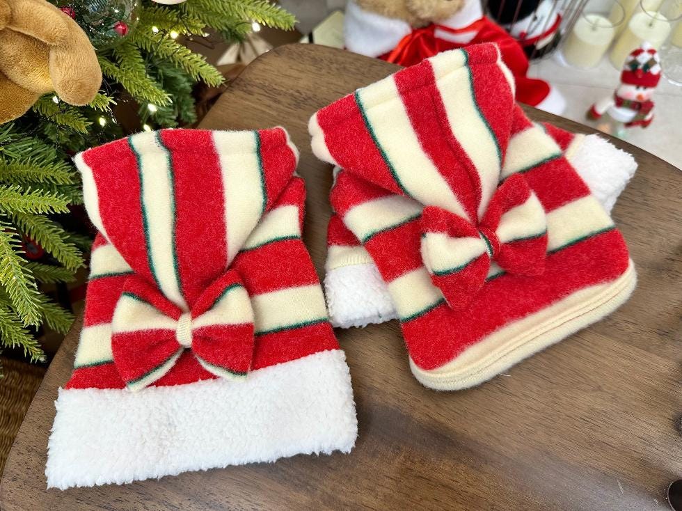 Red and white striped Christmas dog shirts with large bows and white fleece trim.