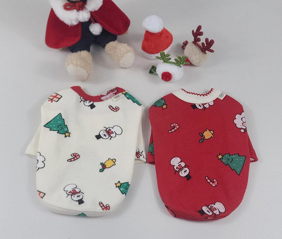 Pair of Christmas dog shirts featuring Santa and reindeer patterns in white and red.