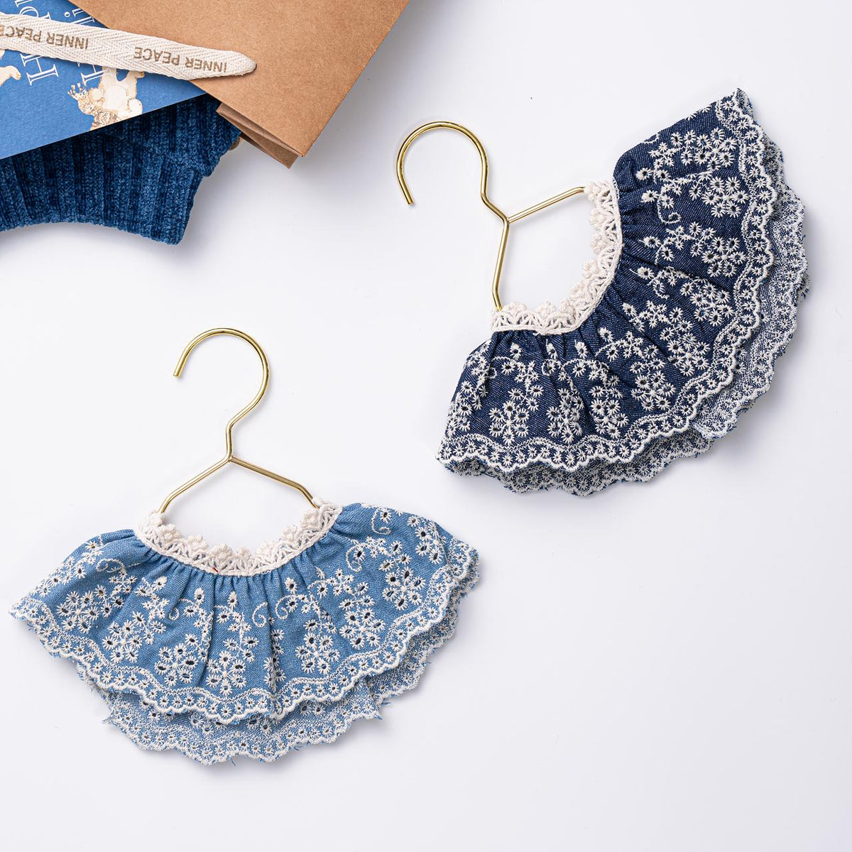 NKpup Denim Lace Bow Cape in light and dark blue denim with white floral lace trim.