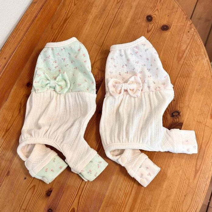 Two Mini Garden dog overalls in mint green and white floral patterns with bow details.