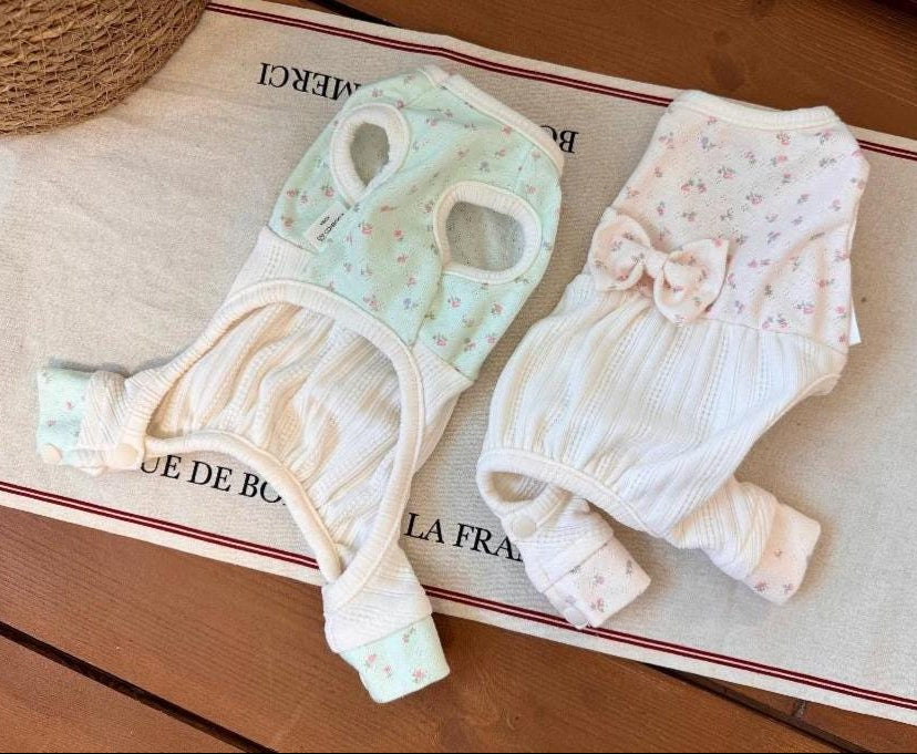 Two Mini Garden Dog Overalls in mint green and white with floral patterns and bow details.