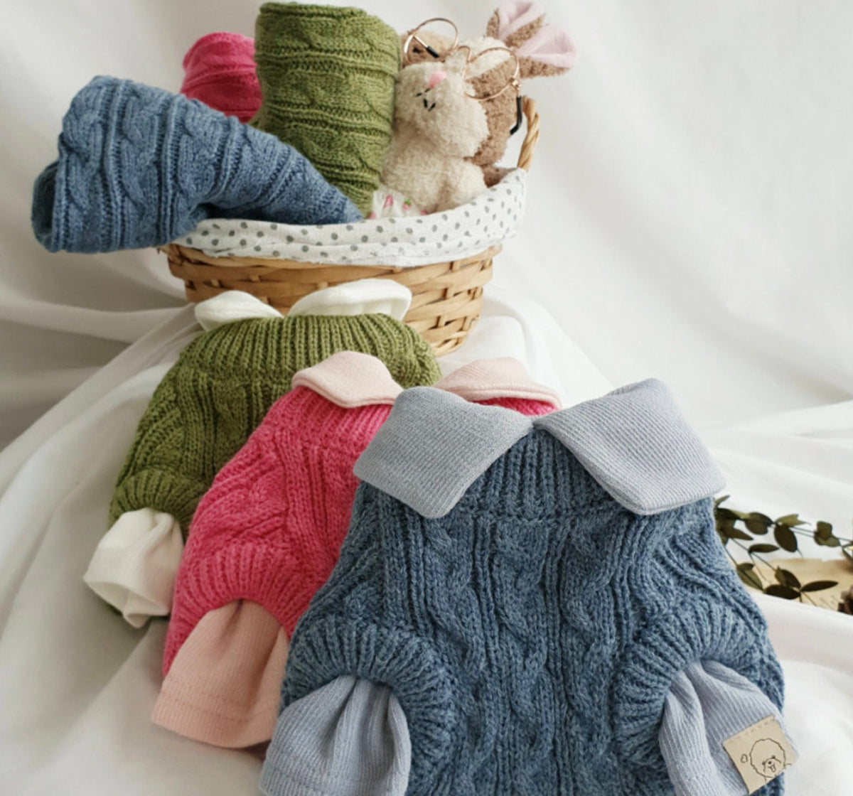 NKpup cable knit dog vests in blue, pink, and olive green with contrasting collars