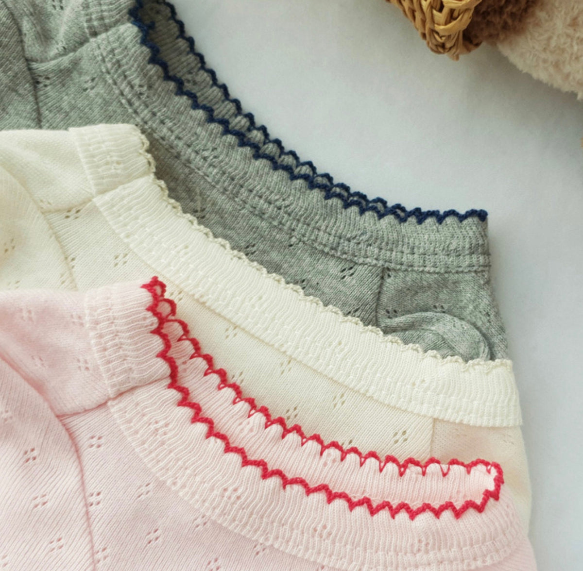 NKpup Basic Ribbed Dog Shirt in pink, cream, and grey with scalloped trim edges.