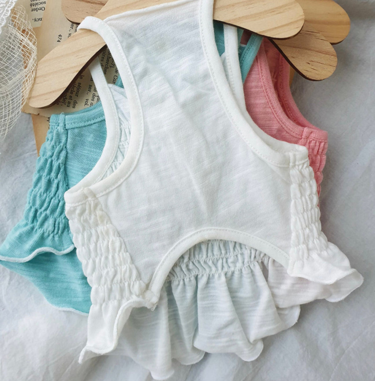 Solid smocked dog crop top in white, light blue, and pink colors.
