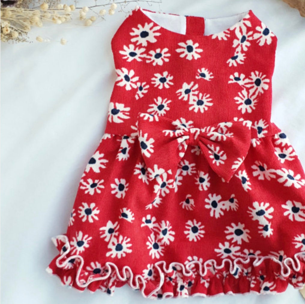 Red floral corduroy dog dress with white daisy pattern and a large bow detail.