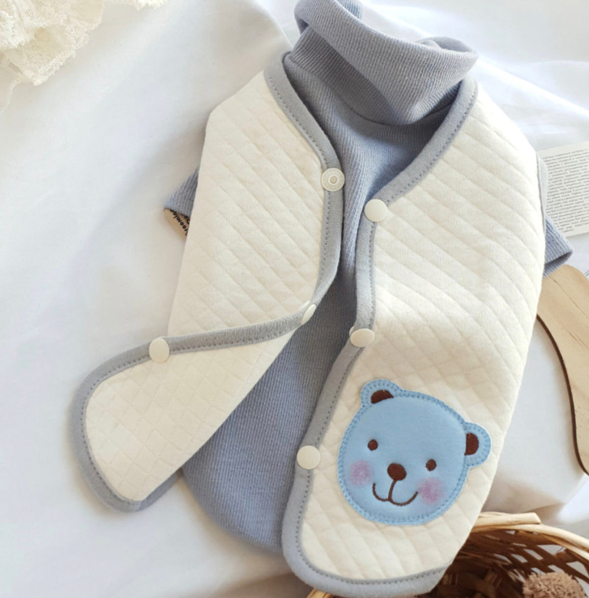 NKpup organic quilted dog vest in cream and light blue with a cute bear patch.