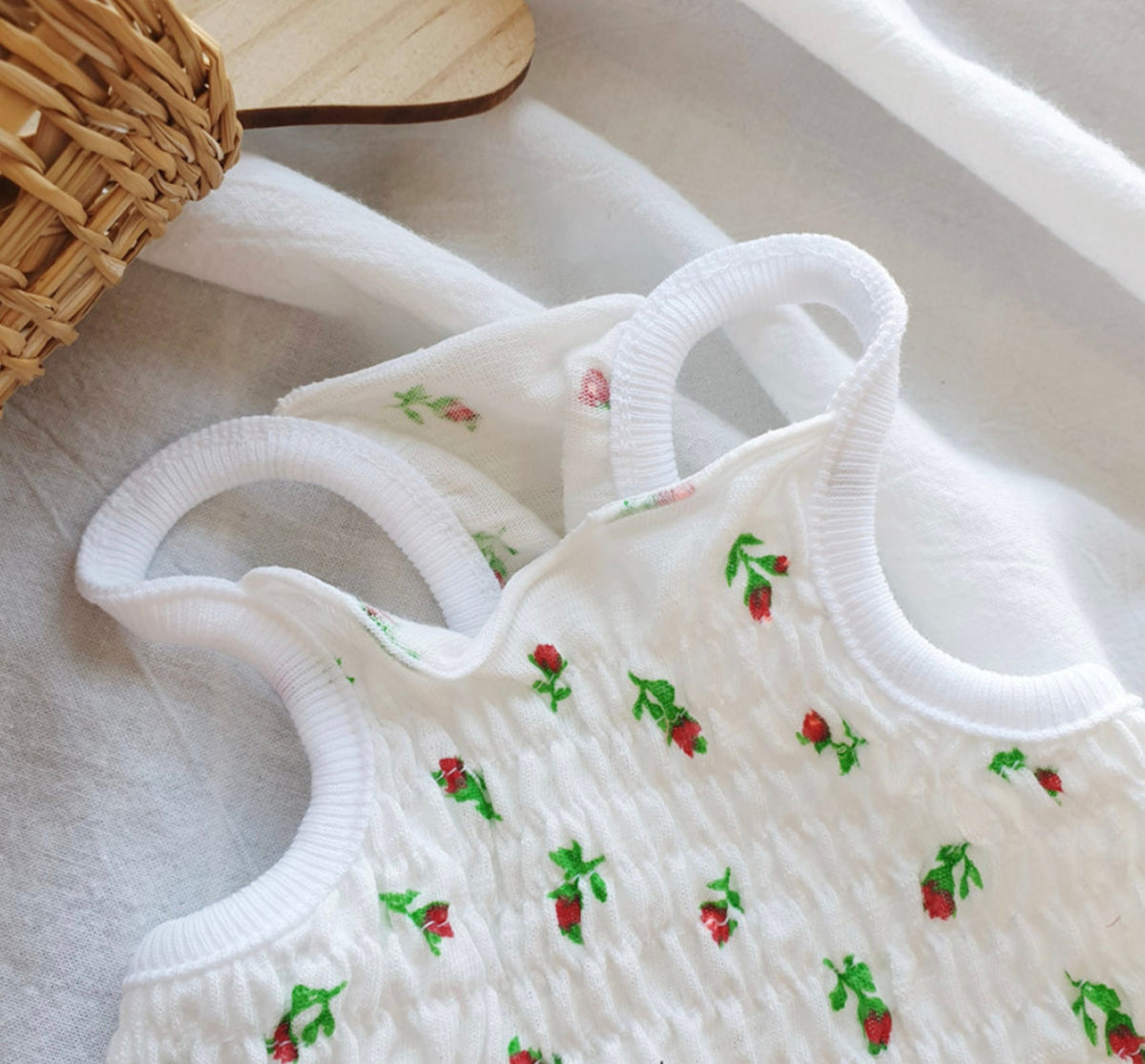White smocked dog crop top with a red rose pattern and thick straps.