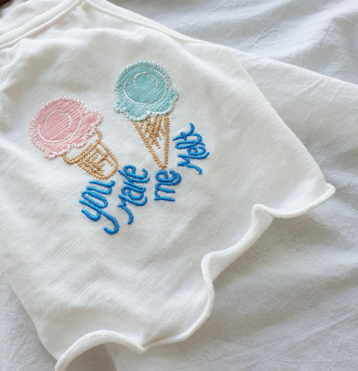 White NKpup dog crop tank top featuring embroidered ice cream cones and the text 'you make me melt'.