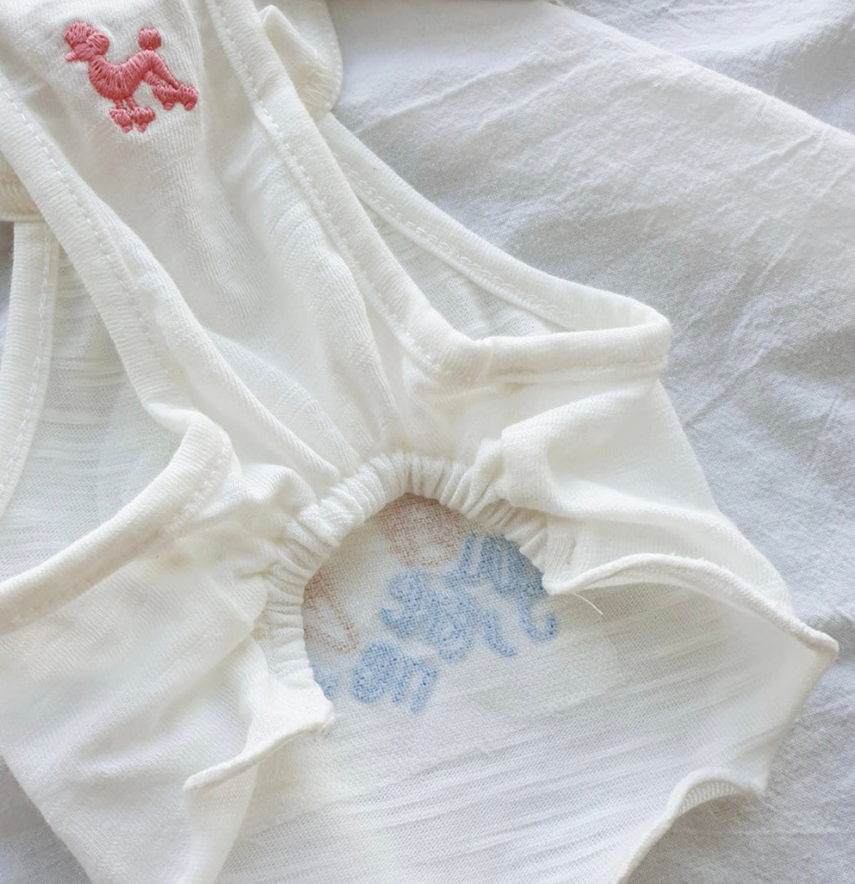 Close-up of a white NKpup Ice Cream Dog Crop Tank Top featuring pink embroidery details.