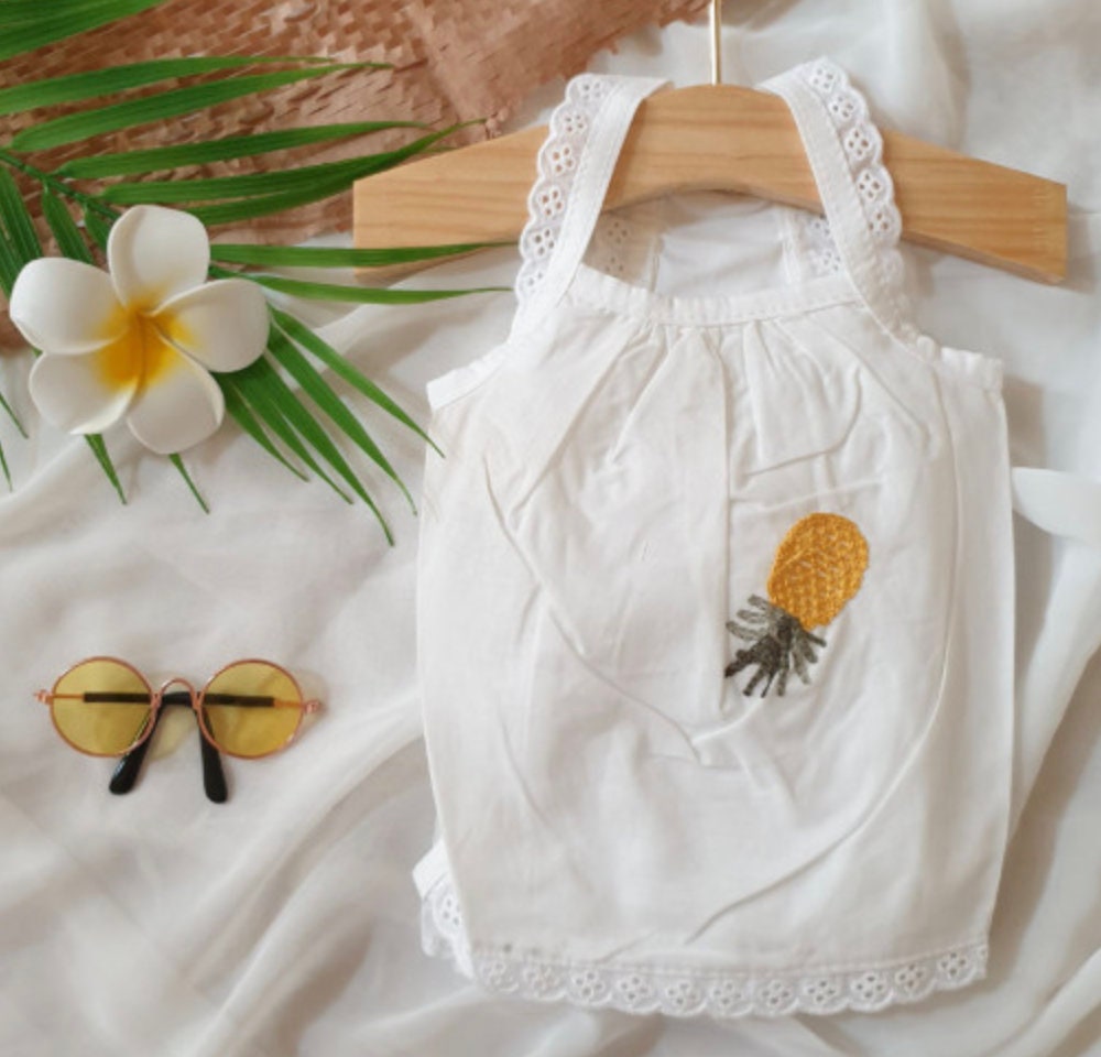 White NKpup embroidered dog tank top with a yellow pineapple pattern.