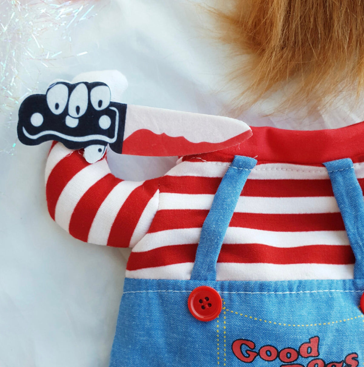 Chucky dog costume featuring a red and white striped shirt and blue denim overalls with a toy knife accessory.