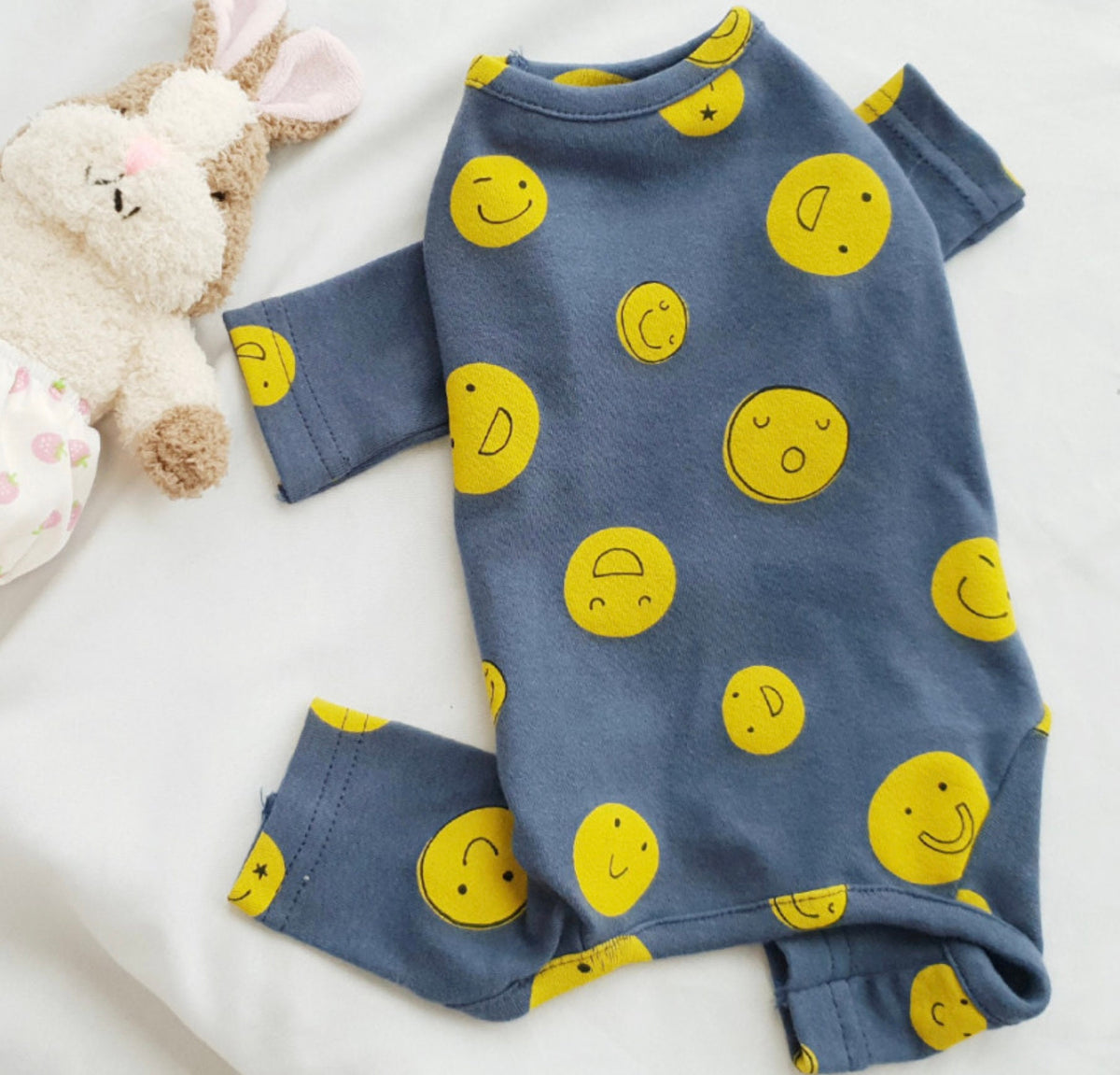 Blue NKpup dog overall featuring a yellow smiley face pattern