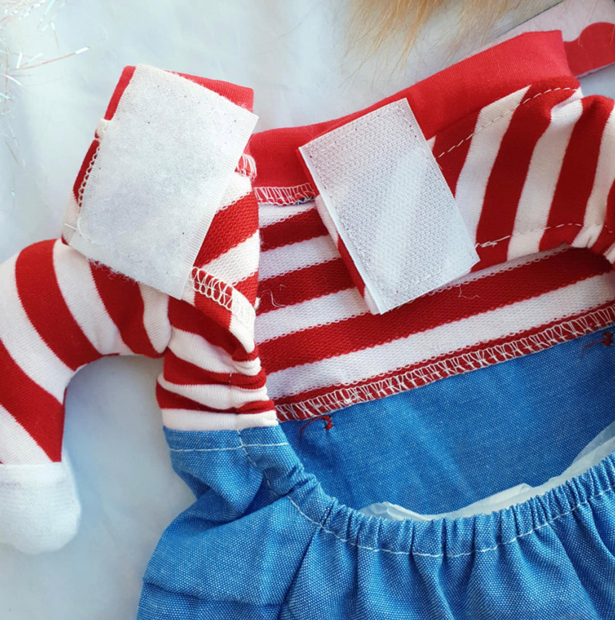 Red and white striped Chucky dog costume with blue denim-style fabric and velcro closures.