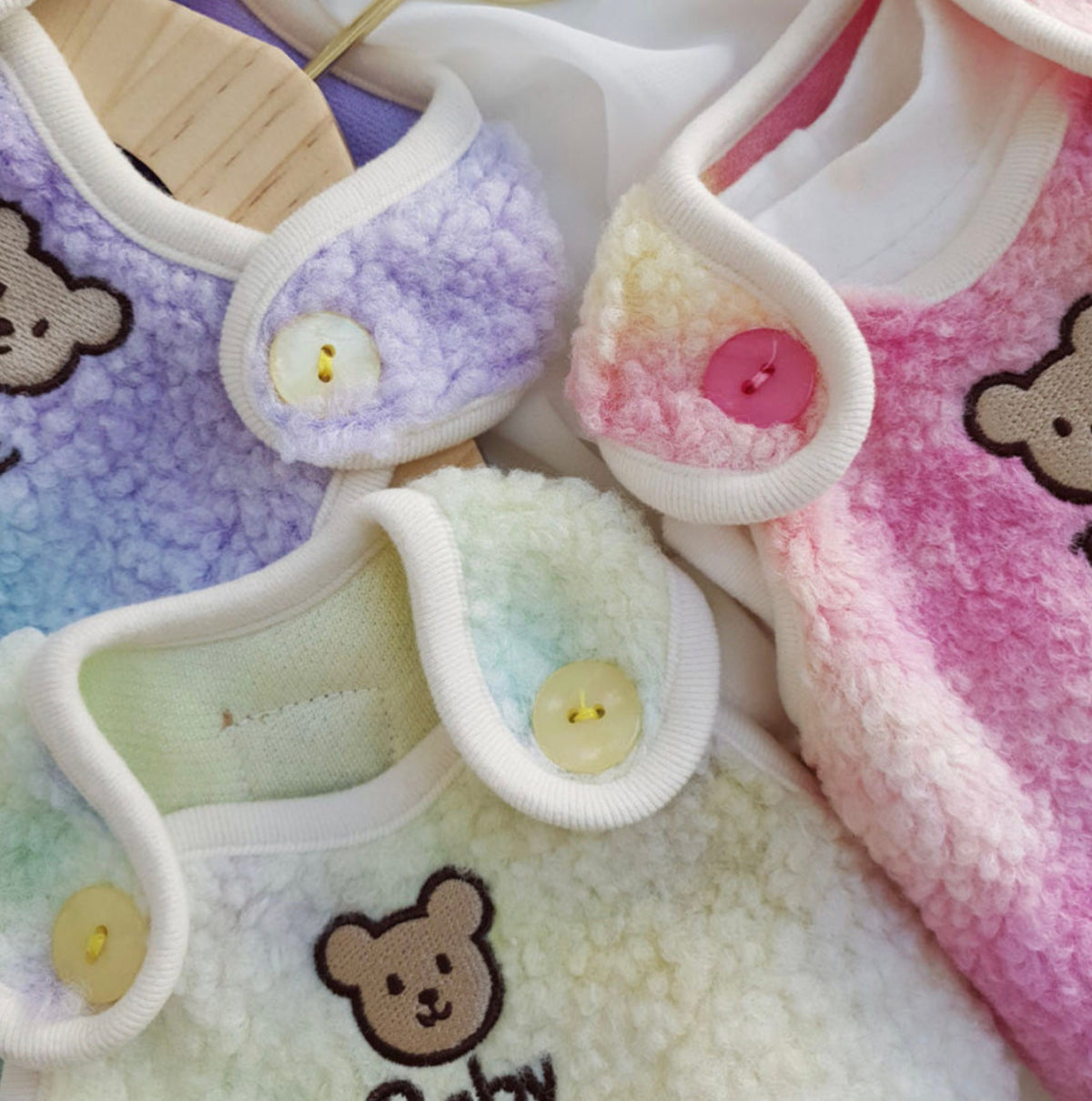 NKpup Aurora Boa Fleece Dog Vests in purple, pink, and pastel yellow with bear embroidery.