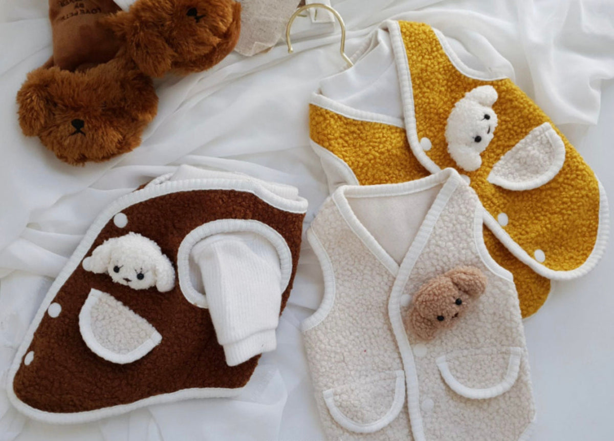 Three NKpup bear fleece dog vests in brown, yellow, and cream colors with teddy bear face details.