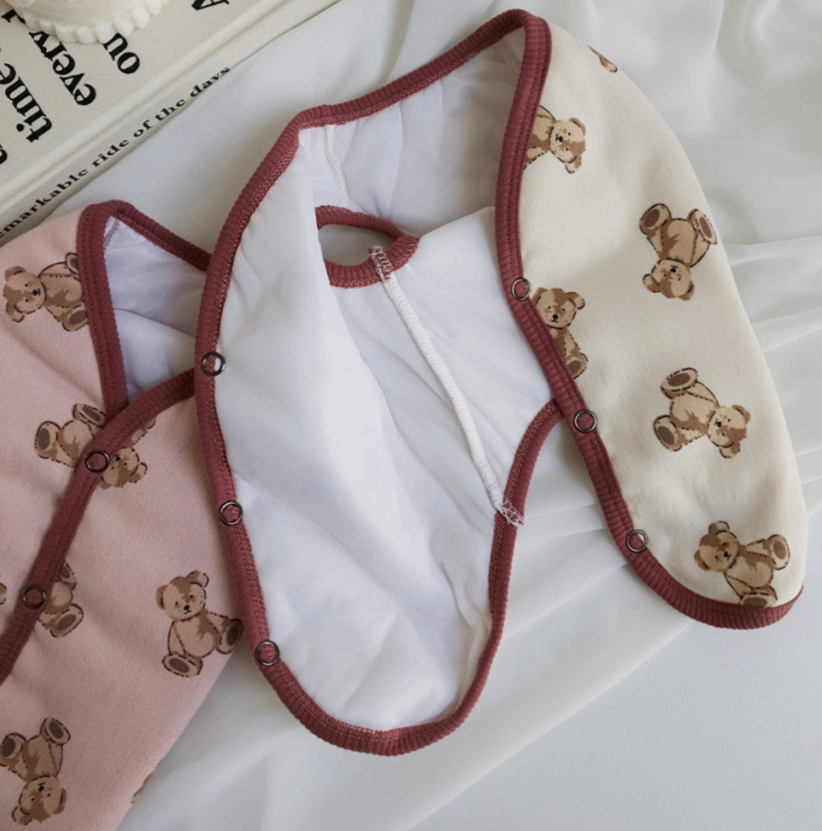 Teddy bear pattern dog vest in pink and cream with brown trim.