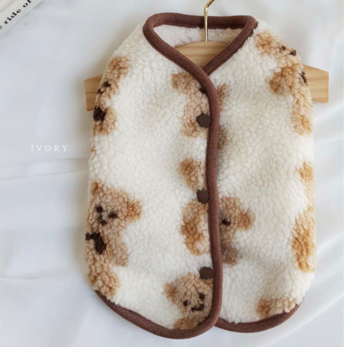 Reversible bear pattern fleece dog vest in white and brown.