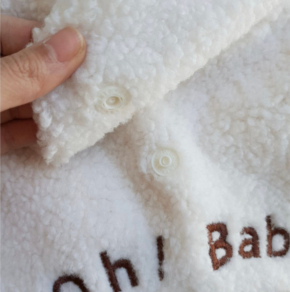 White fleece dog hoodie vest with button closures and brown embroidery