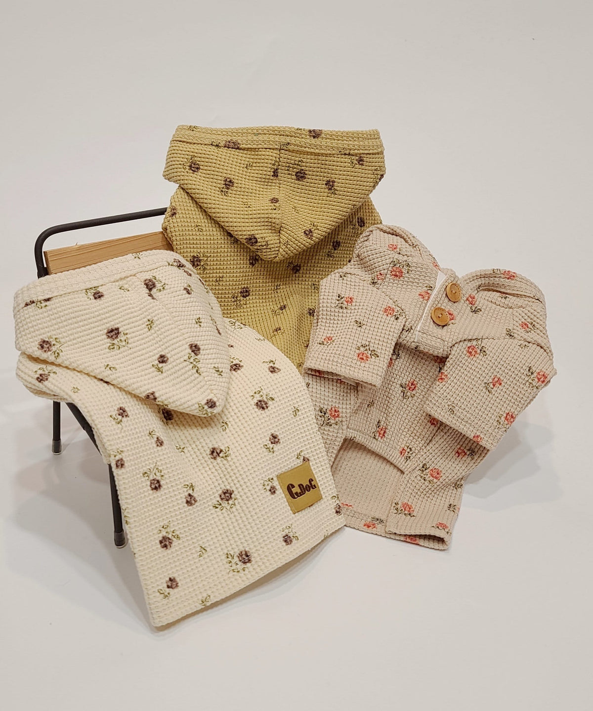 Three floral waffle hoodie pullovers for dogs in cream and mustard yellow colors.