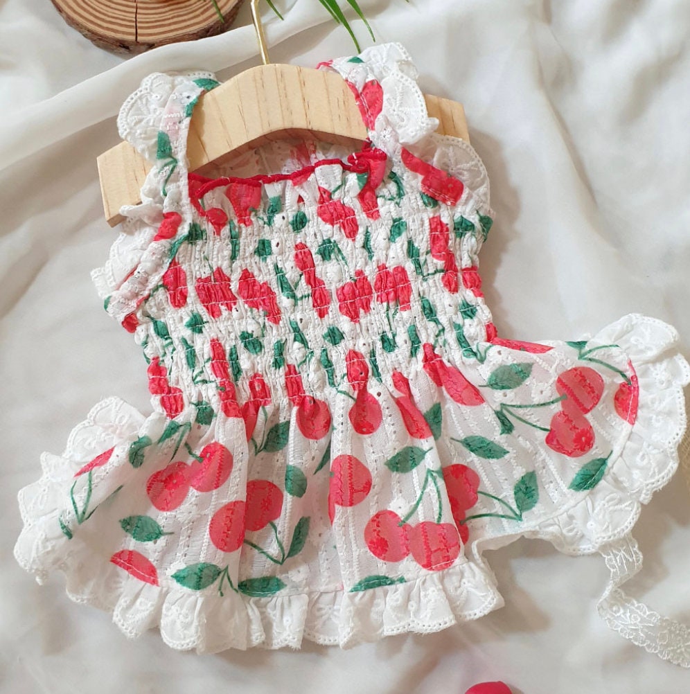 NKpup Fruits Dress featuring a white lace pattern with red cherry prints and ruffled edges.